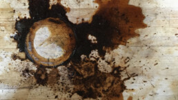 A black coffee spill on a wood counter